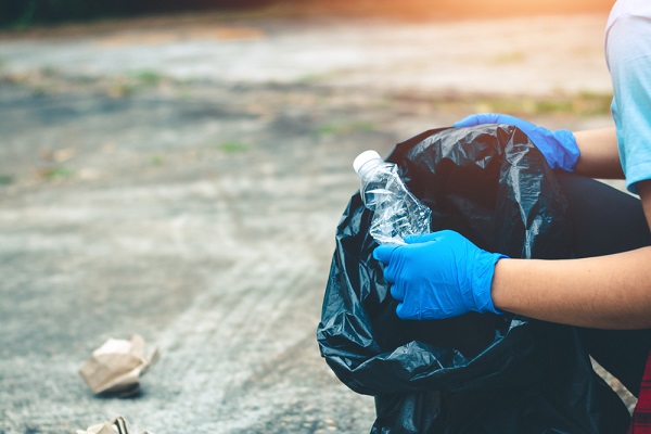 volunteer helping clear up non-recyclable plastic