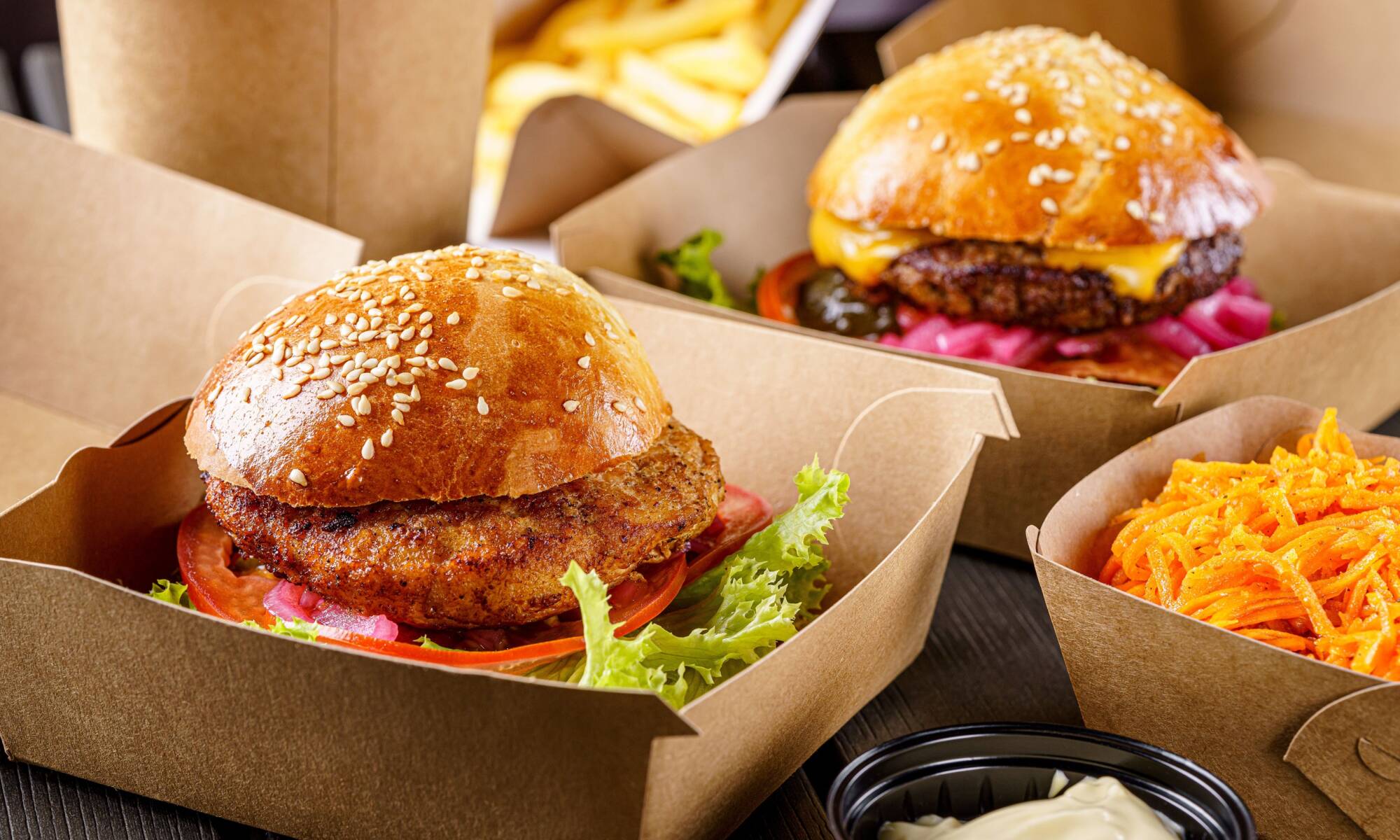 Street food. Meat cutlet burgers are in paper boxes. Food delivery.